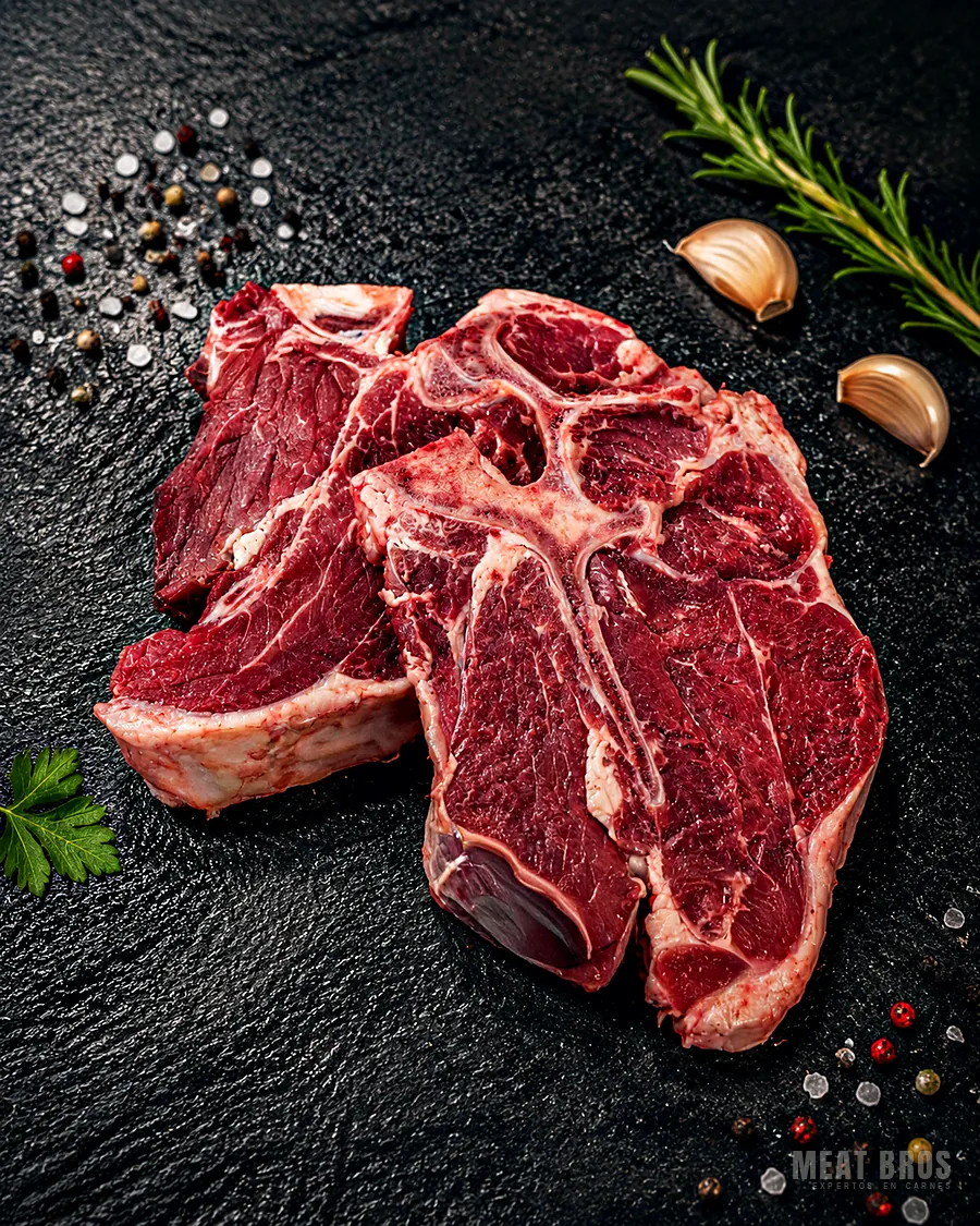 Dos porterhouse de res crudos, con lomo fino amplio a un lado del hueso