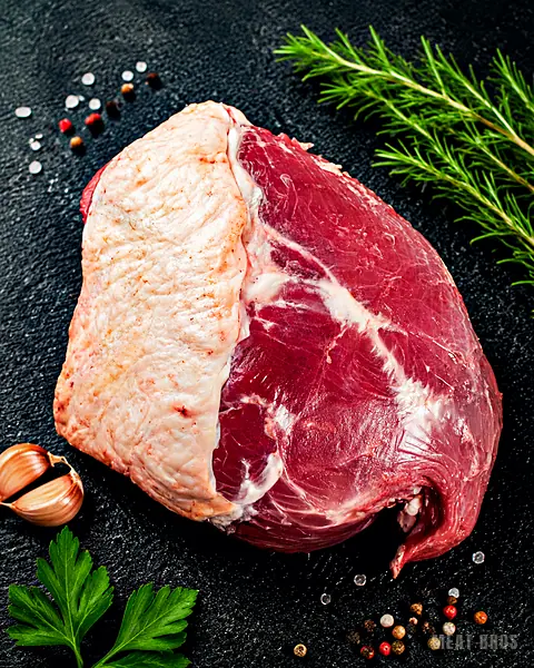 Pieza de res con capa de grasa y vetas, con romero fresco